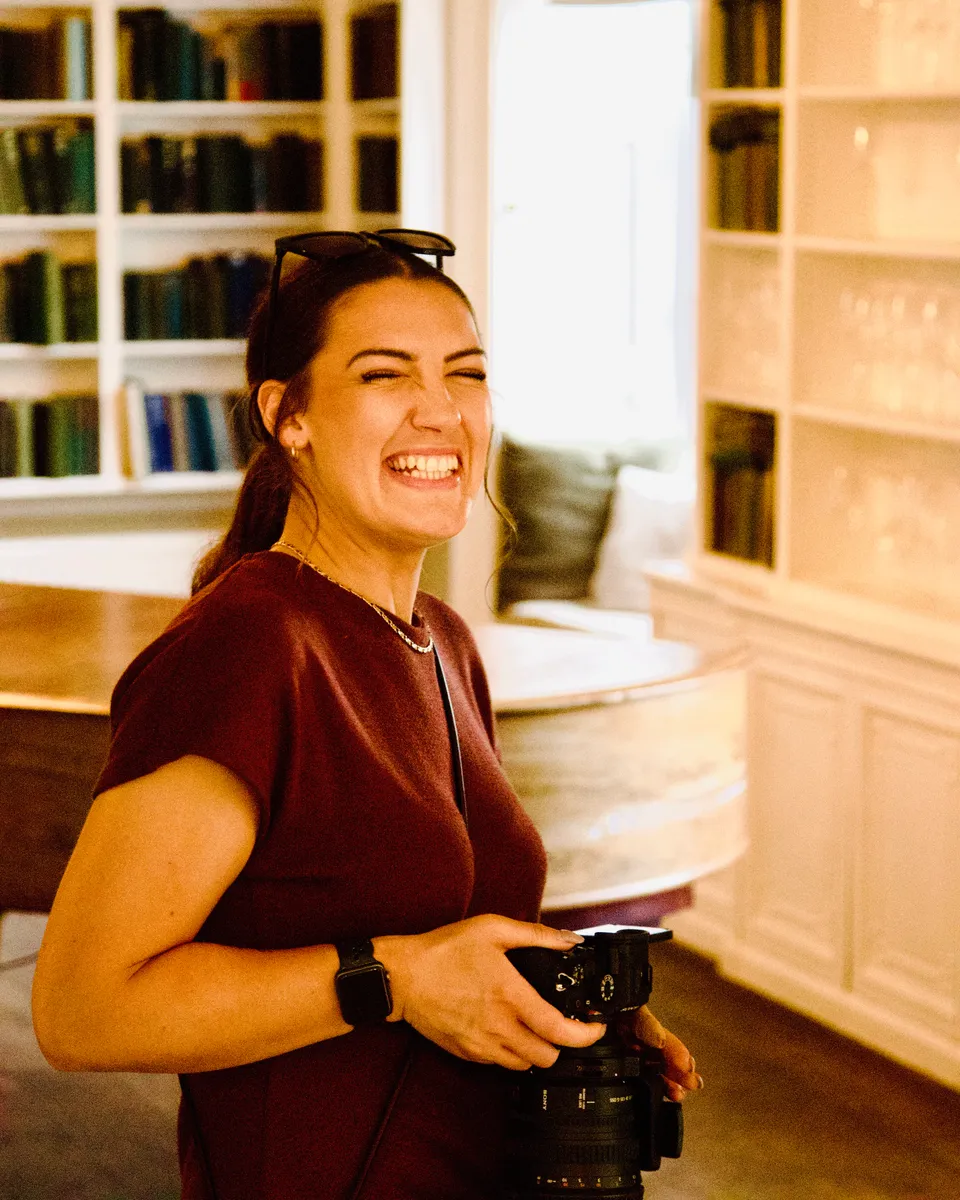 Cassandra laughing, holding a camera